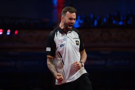 Ross Smith celebrating during a darts match.