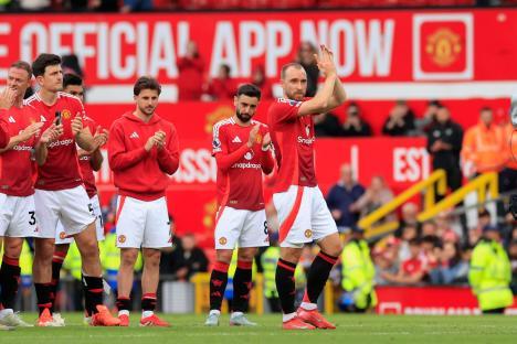 Manchester United players applauding fans.
