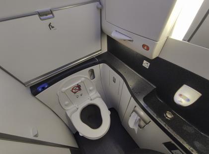 Airplane lavatory with toilet and sink.