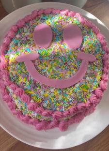 DIY smiley face birthday cake decorated with sprinkles.
