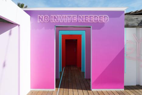 Pink building with neon sign reading