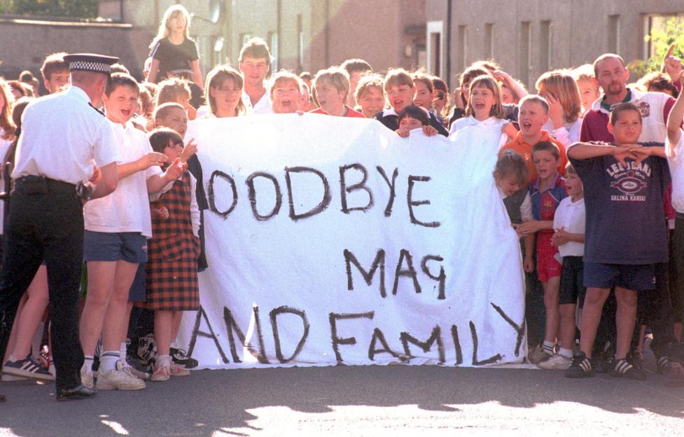 Children holding a sign that says "Goodbye Mag and Family."