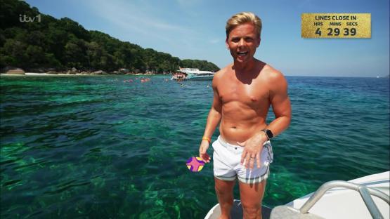 Jeff Brazier shirtless on a boat in clear water.