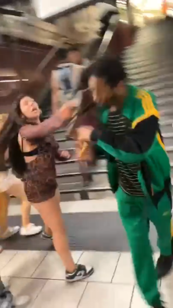 Two people fighting at a tube station.