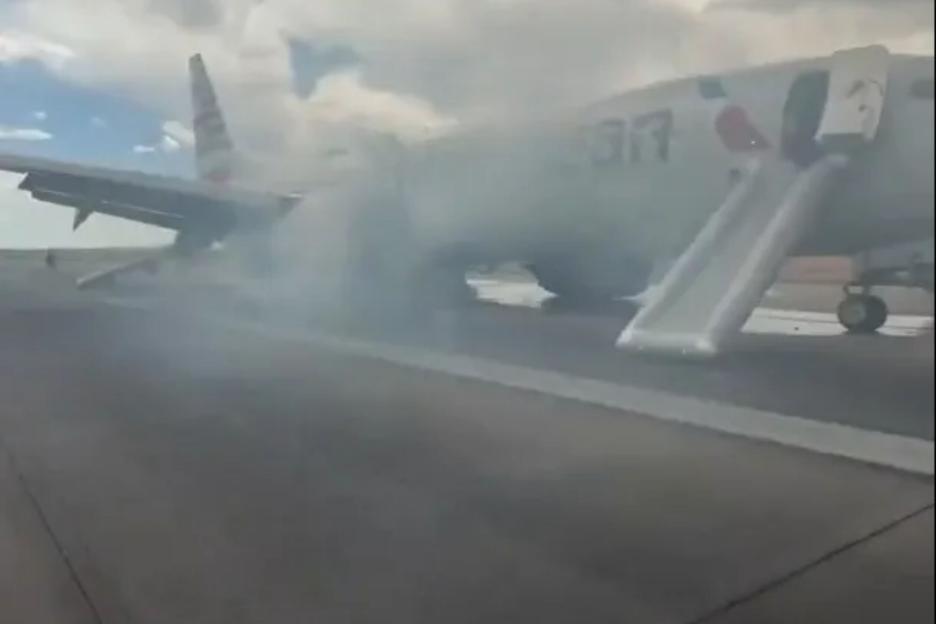 Moment 150 terrified passengers flee plane engulfed in smoke after landing gear issue sparked fire and injured one