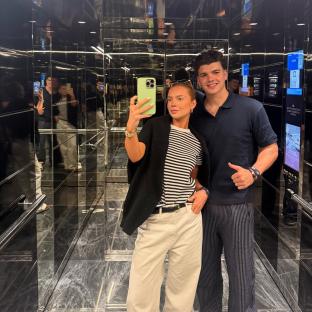 Harry Clark and a woman taking a selfie in an elevator.