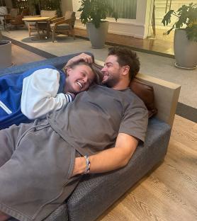 Couple cuddling on a couch.
