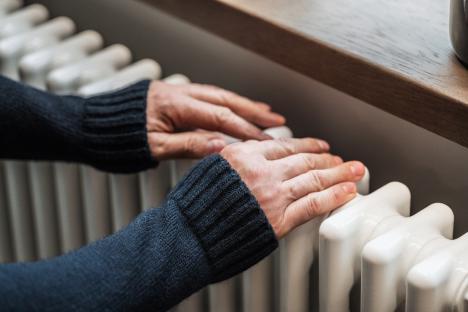 Person warming hands on a radiator.