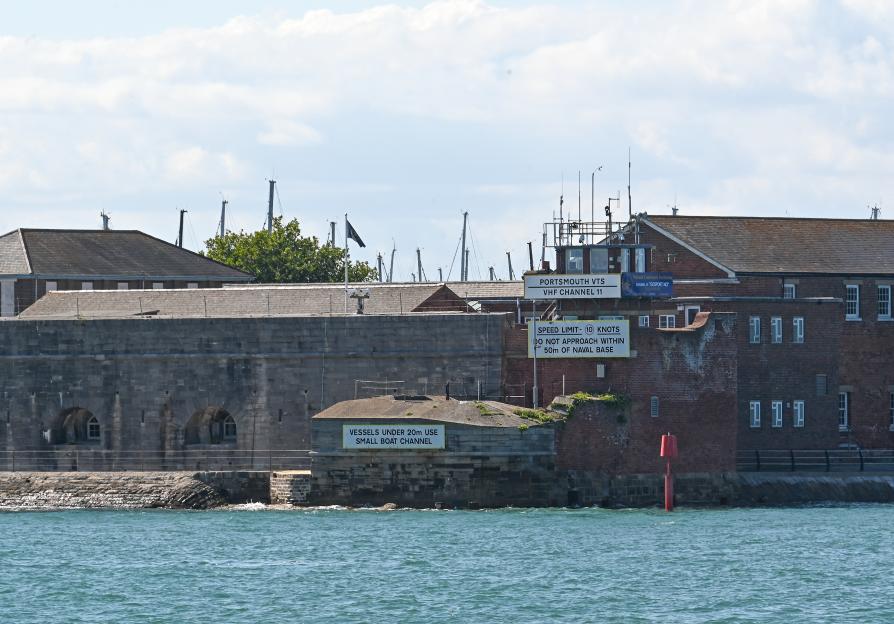 Fort Blockhouse, an old fort and brick buildings, by the sea with signs about boat channels and speed limits.