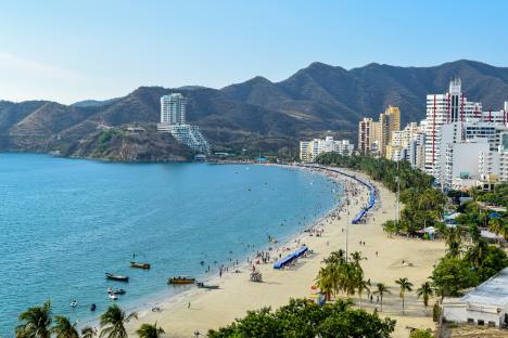 Beach in Santa Marta, Colombia, with hotels and people.