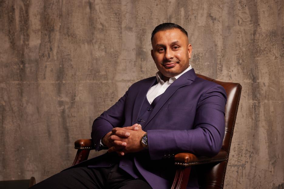Portrait of a man in a purple suit.