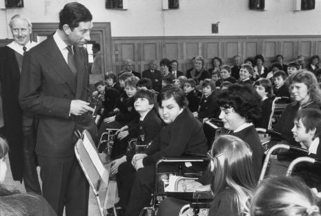 Black and white photo of students at Treloar College participating in archery. One student is in a wheelchair.