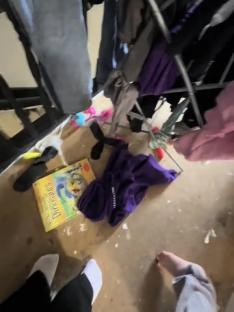 A cluttered floor in a two-bedroom home with a pregnant mother expecting another child.