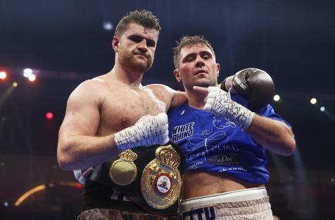 Johnny Fisher and David Allen after a boxing match, Fisher with a championship belt.