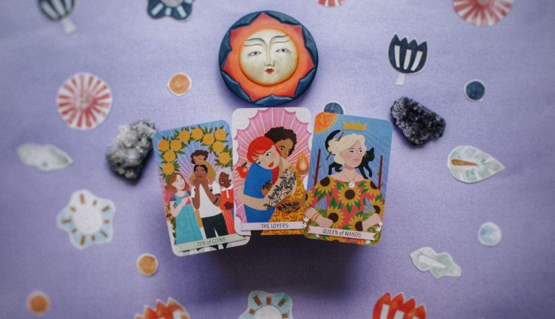 Three tarot cards: Ten of Coins, The Lovers, and Queen of Wands, surrounded by small illustrations and crystals.