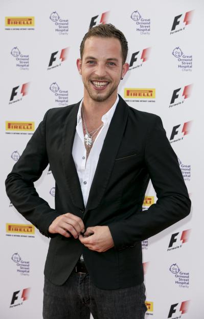 James Morrison smiling at the F1 party with logos for Pirelli and Great Ormond Street Hospital Charity in the background.