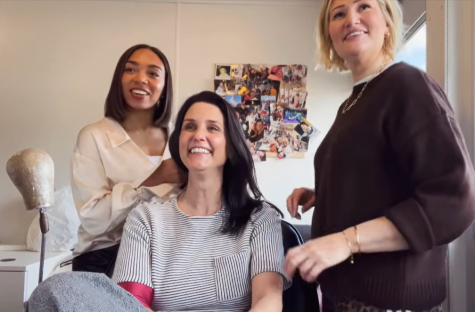 Three women smiling, one in a striped shirt.