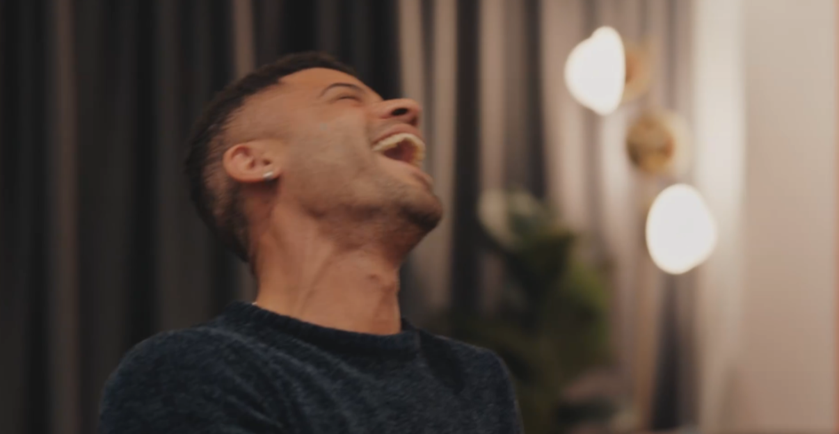 A man laughing with his head tilted back.