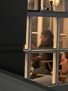 Photo of Zara McDermott and Louis Tomlinson seen through a window.