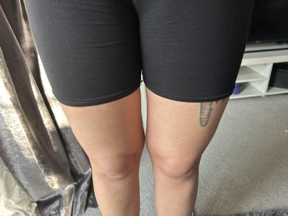 Woman's legs in black shorts with an elephant tattoo that resembles a penis.