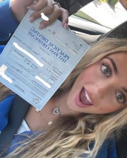Woman holding a driving test pass certificate.