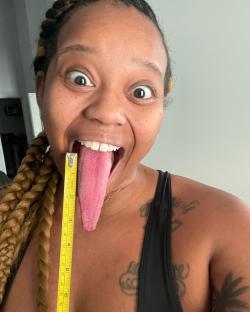 Woman measuring her exceptionally long tongue with a tape measure.