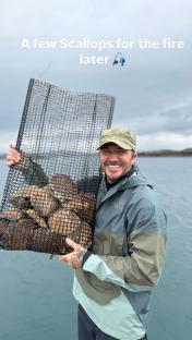 Man holding a net full of scallops.