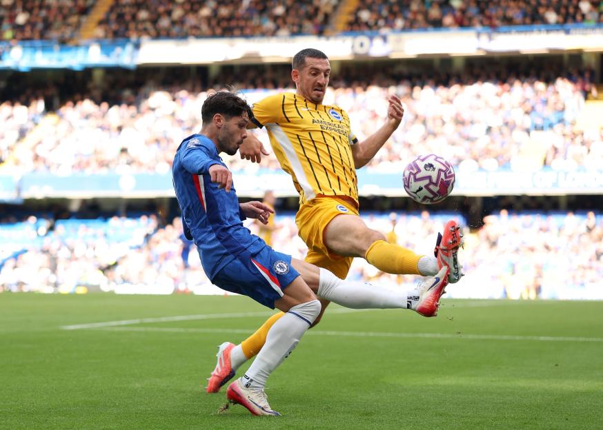 Pedro Neto of Chelsea being challenged by Lewis Dunk of Brighton & Hove Albion during a Premier League football match.
