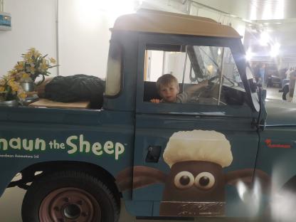Shaun the Sheep-themed truck with a young boy inside.