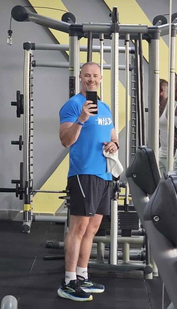 A man named Dave Stewart taking a mirror selfie in a gym.