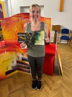 Woman holding weight loss awards.
