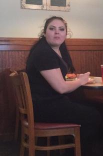 A waitress eating at a restaurant table.