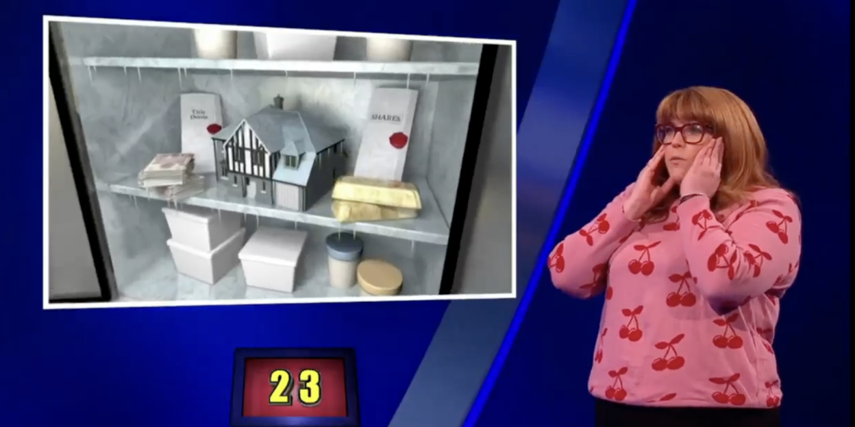 Screenshot of a game show contestant reacting to an image of a refrigerator containing cash, a house model, gold bars, and shares. The number 23 is displayed.