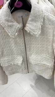 White tweed jacket on a hanger.