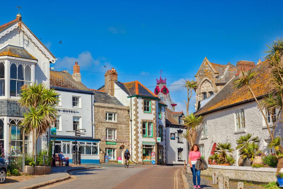 Marazion, Cornwall, UK village with shops, people, and palm trees.