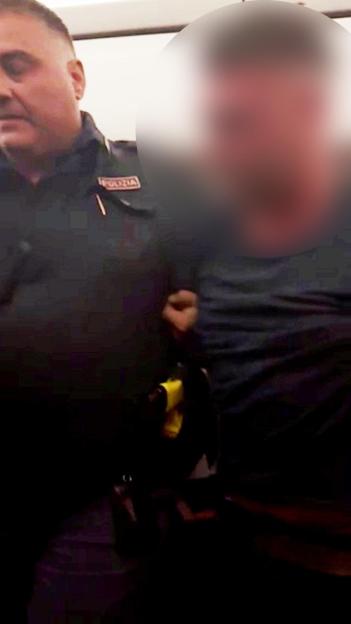 Police officer dragging a passenger holding a bottle of vodka off an EasyJet flight.