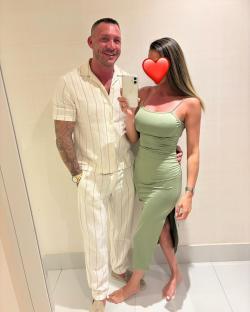 Couple taking a selfie in matching outfits.