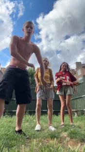 Three people dancing outdoors.