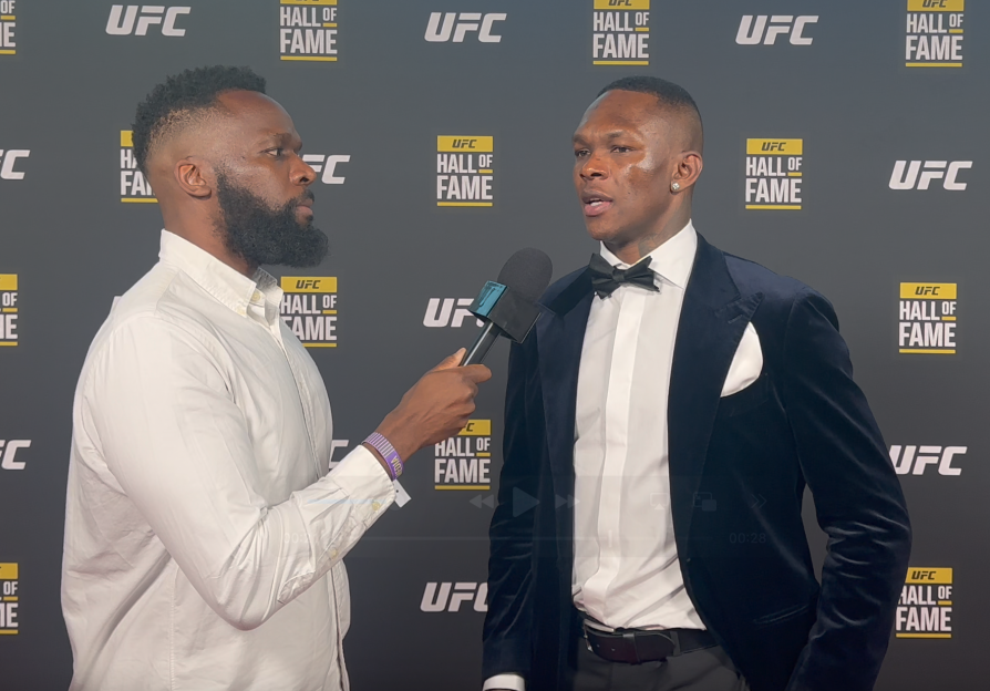 A man in a suit being interviewed at a UFC Hall of Fame event.