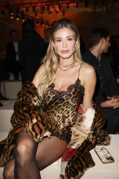 Diletta Leotta wearing a leopard print dress and fur coat at the Roberto Cavalli fashion show.