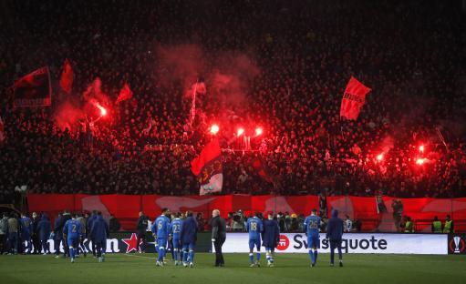 Crvena Zvezda fans with flares in the stands after a soccer match.