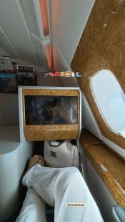 Person's legs and feet in first-class airplane seat.