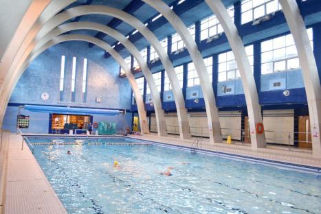 Interior view of Mounts Baths Northampton, showing an Art Deco-style swimming pool with people swimming.