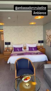 Ambassador cruise line suite with twin beds and sitting area.