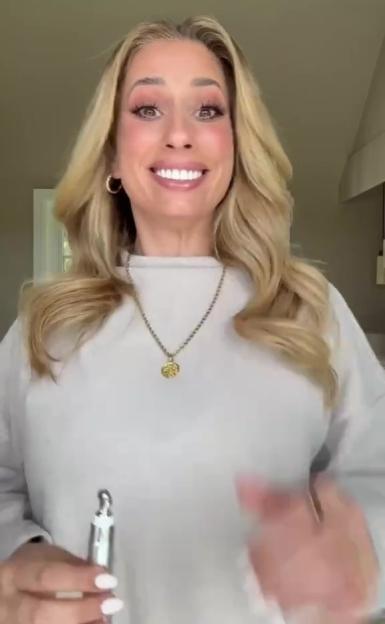 Stacey Solomon smiling and holding a beauty tool.