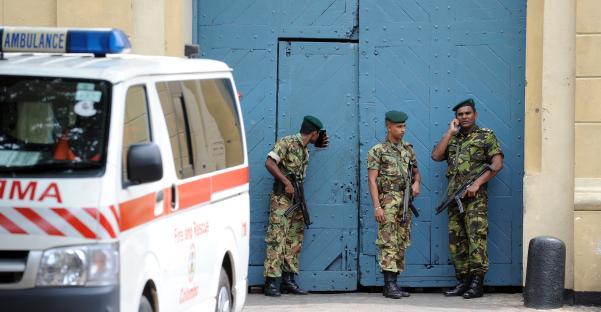 Sri Lankan policemen guarding a prison gate after a drug raid.