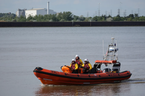 RNLI lifeboat with crew on river.
