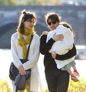 Tom Cruise, Katie Holmes, and their daughter Suri walking together.