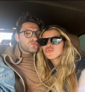Close-up selfie of a couple making kissy faces.
