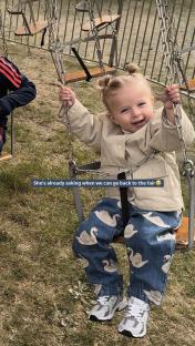 Toddler on a fairground swing.